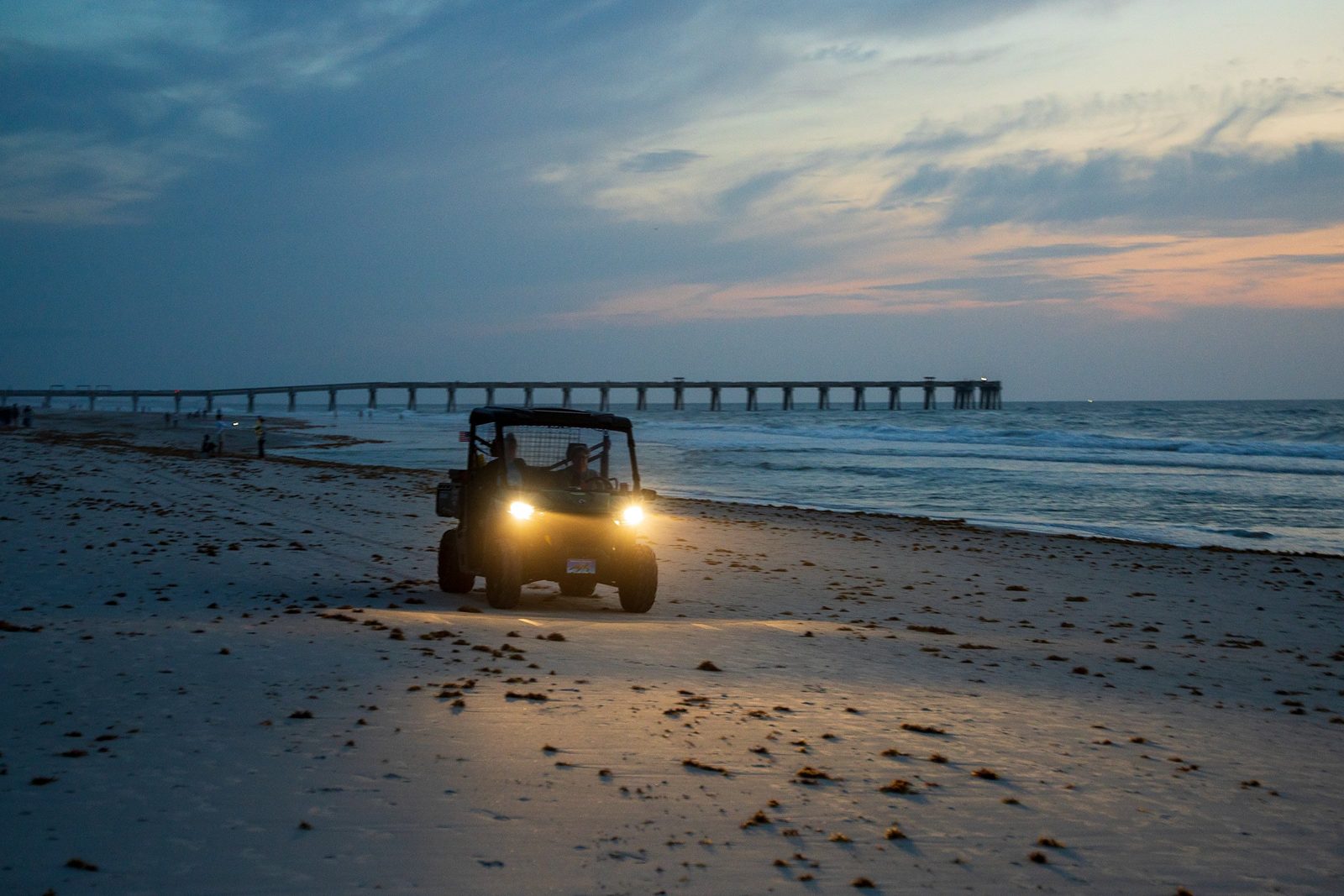 A Beaches Sea Turtle Patrol UTV crosses the sand at first light near the Jacksonville Beach Pier